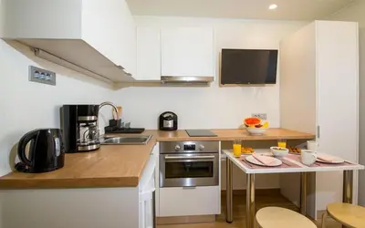 a kitchen with white cabinets and a counter with a sink at Modern Chic Studio - Chania City Center - Parking in Chania Town
