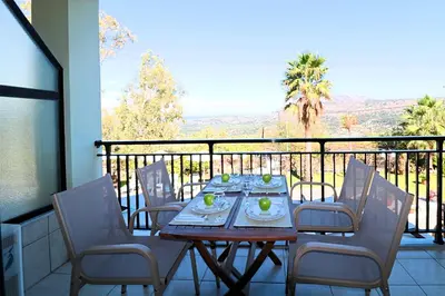 a table and chairs on a balcony with a view at Kalimera Apartments in Vamos