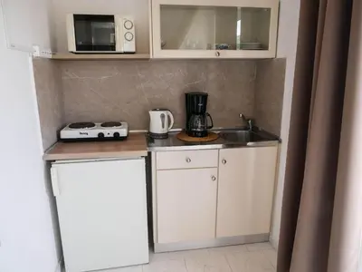 a small kitchen with a sink and a microwave at Litinas Apartments with pool in Agia Marina Nea Kydonias