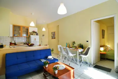 a living room with a blue couch and a kitchen at Sweet Home Lena Feel like home in Chania Town