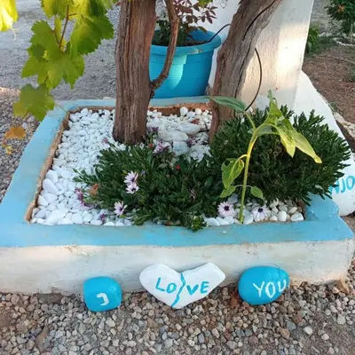 a garden with rocks and a tree with the words love at Casa D'armaros in Kissamos