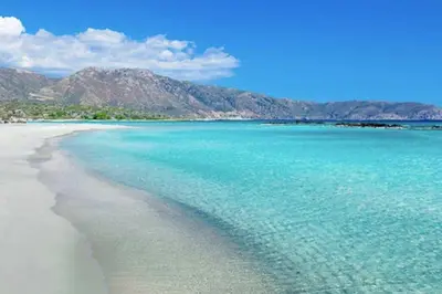 a beach with blue water and mountains in the background at Casa D'armaros in Kissamos