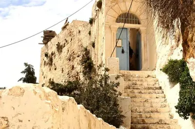 a stone building with stairs leading to a door at Casa D'armaros in Kissamos