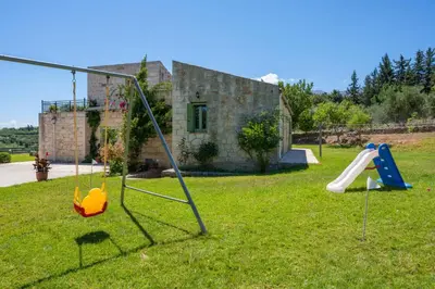a yard with a playground with a house at BOUTIQUE VILLA PETRA AMANDA Heated pool optional in Fílippos