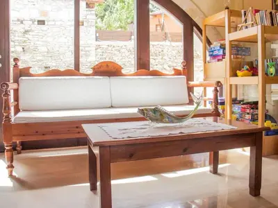 a bench in a room with a table at Group Accomodation, Heliopetra Studios And Houses in Douliana