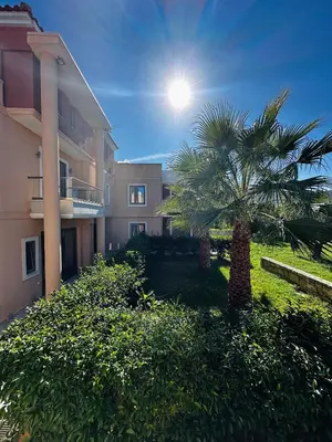 a palm tree in a yard next to a building at Golden Victory in Agia Marina Nea Kydonias