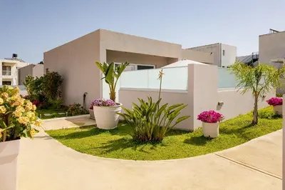 a house with potted plants in front of it at Sarpidon Suites in Agia Marina Nea Kydonias