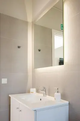 a bathroom with a white sink and a mirror at Sarpidon Suites in Agia Marina Nea Kydonias