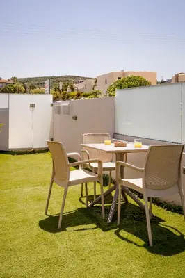 a table and chairs sitting on top of a yard at Sarpidon Suites in Agia Marina Nea Kydonias