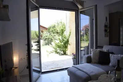 a living room with a couch and a sliding glass door at Ocean Breeze Apartments in Gerani Chanion