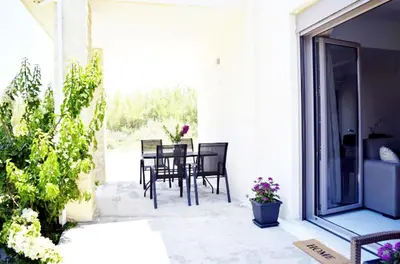 a patio with chairs and a table with flowers at Ocean Breeze Apartments in Gerani Chanion