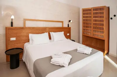 a bedroom with a bed with towels on it at Alexandra Beach Hotel in Agia Marina Nea Kydonias