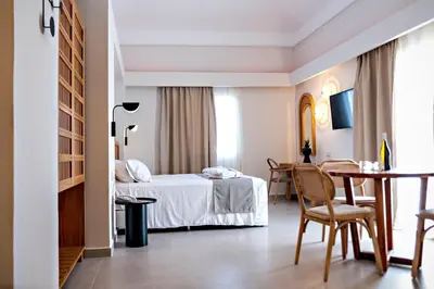 a hotel room with a bed and a table at Alexandra Beach Hotel in Agia Marina Nea Kydonias