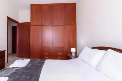 a bedroom with a large bed with wooden cabinets at Voula's Place in Chania Town
