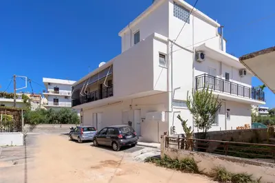 a white building with cars parked in front of it at Voula's Place in Chania Town