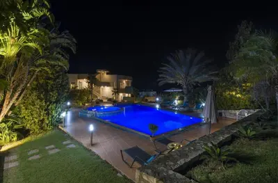a swimming pool in a yard at night at Villa Elina Luxury Residence in Stalos