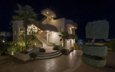 a large white house with palm trees in front of it at Villa Elina Luxury Residence in Stalos