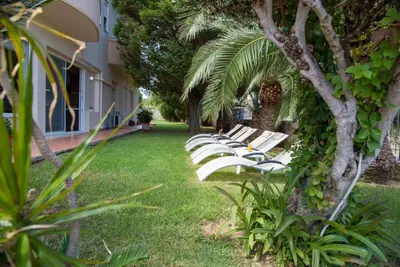 a row of white benches sitting in the grass at Villa Elina Luxury Residence in Stalos