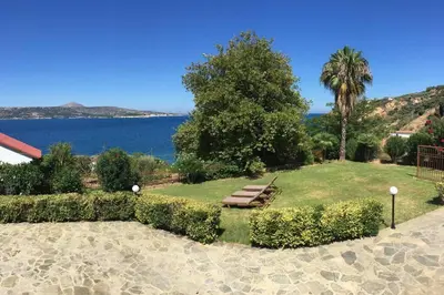 a park with a bench and a view of the water at Villa Melpomeni in Sinoikismós Plakálona