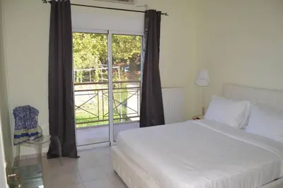 a bedroom with a bed and a large window at Villa Melpomeni in Sinoikismós Plakálona