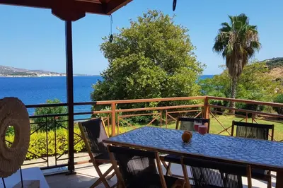 a table on a balcony with a view of the ocean at Villa Melpomeni in Sinoikismós Plakálona