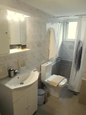 a bathroom with a white sink and a toilet at Meryland in Chania Town