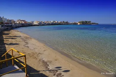 a beach with a yellow sign on the shore at Meryland in Chania Town