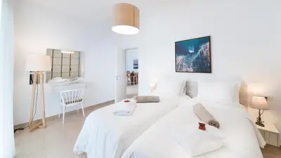 a white bedroom with two beds and a desk at Luxury Villa Mystique with Amazing Seaview in Chania Town