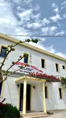 a white building with a sign on it at Mesohori studios in Sfakiá