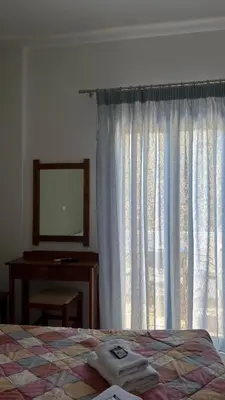 a bedroom with a bed and a desk and a window at Mesohori studios in Sfakiá