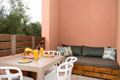 a patio with a table and a couch at Iliana Apartments in Falasarna