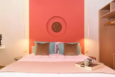 a bedroom with a bed with a red wall at Iliana Apartments in Falasarna