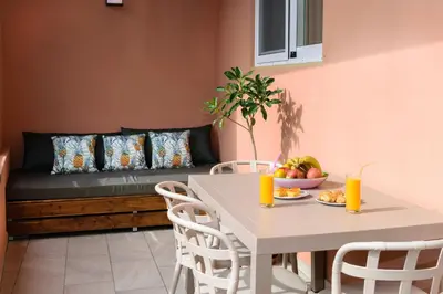 a table and chairs with a couch in a room at Iliana Apartments in Falasarna