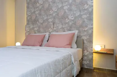 a bedroom with a large bed with pink pillows at Iliana Apartments in Falasarna
