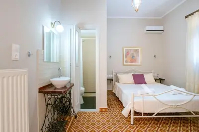 a bedroom with a bed and a bathroom with a sink at Grandma's Chic Home in Chania Venetian Harbor in Chania Town