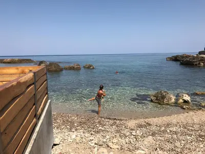 a man standing in the water on a beach at Aristokosmos in Chania Town
