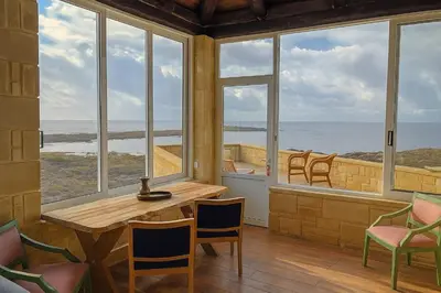a room with a table and chairs and a view of the ocean at Elafonisi Villa above the Beach in Elafonisi