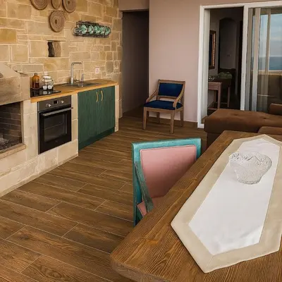 a kitchen and living room with a wooden table at Elafonisi Villa above the Beach in Elafonisi