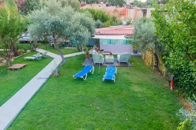 a garden with chairs and a table and a house at Chania Green House 1 in SFakianalíon