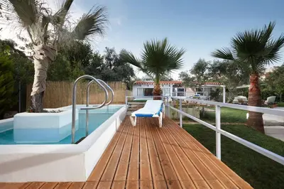 a deck with a pool and a chair on top of it at Chania Green House 1 in SFakianalíon