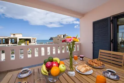 a table with fruits and vegetables on a balcony at Manolia Dream Apartment 3-bedrooms 30m to the beach in Agia Marina Nea Kydonias