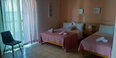 a hotel room with two beds and a chair at Posidonio Hotel in Chania Town
