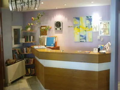 a reception desk in a library with a book shelf at Posidonio Hotel in Chania Town