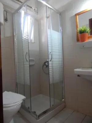 a bathroom with a shower with a toilet and a sink at Posidonio Hotel in Chania Town