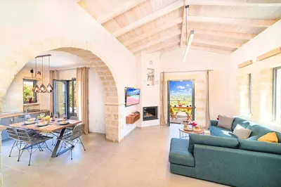 a living room with a blue couch and a table at Villa Vardis Heated Pool in Vryses