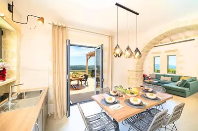 a kitchen and living room with a table and chairs at Villa Vardis Heated Pool in Vryses