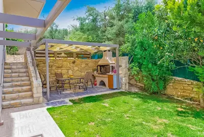 a patio with a table and a grill in a yard at Villa Panagiotis Chania in Daratso