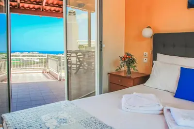 a bedroom with a bed and a view of the ocean at Villa Panagiotis Chania in Daratso