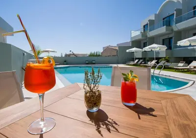 a table with two cocktails on a table next to a pool at Incognito Creta Luxury Suites and More in Kolymvari