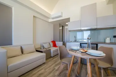a kitchen and living room with a table and a couch at Incognito Creta Luxury Suites and More in Kolymvari